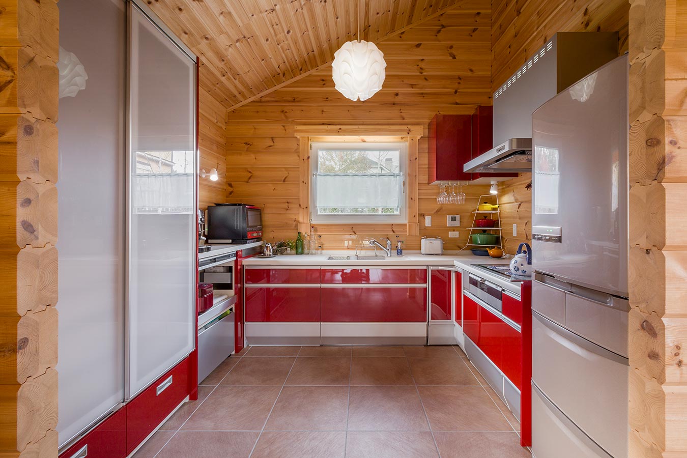 赤と白のコの字型のキッチンは収納キャビネットも多く設置できます。