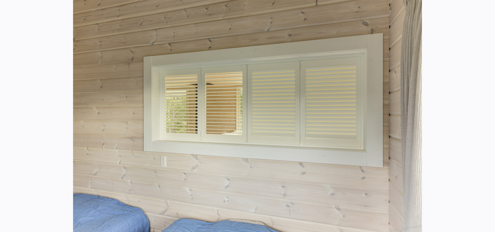 ロフトの寝室に設けた、ブラインド状に開閉できる両開きの室内窓。