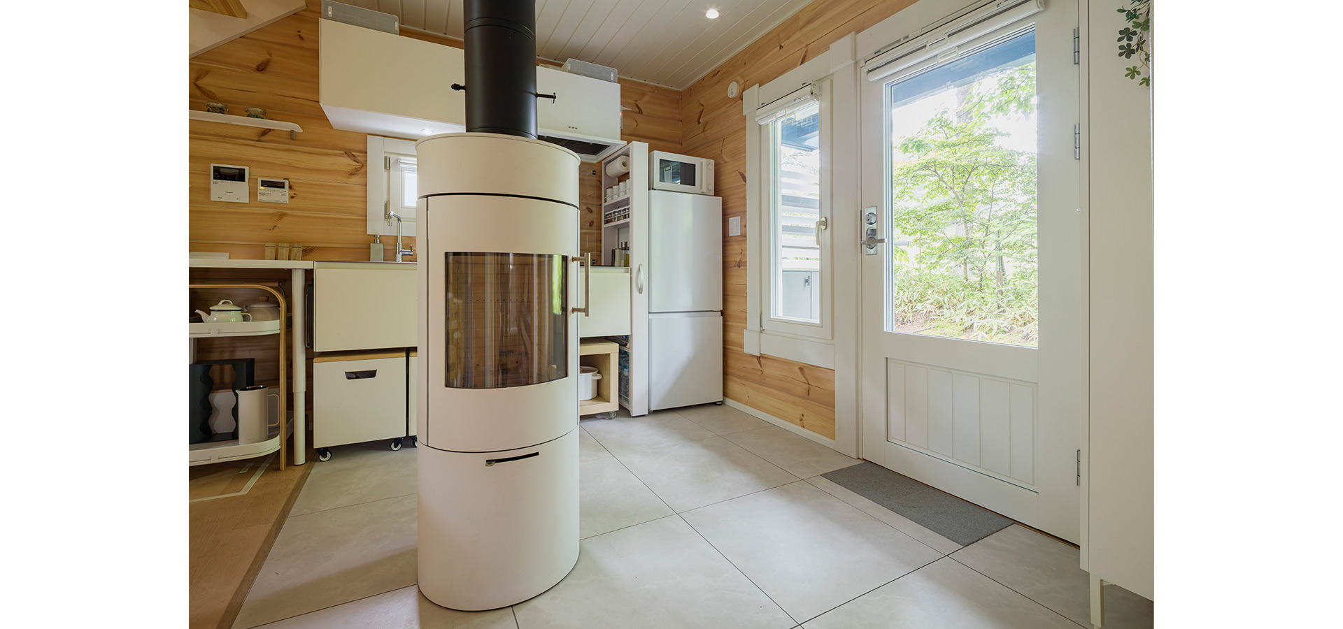 テラスと一続きのエントランスを入るとダイニングへ。中央には、360度回転式の薪ストーブを配置